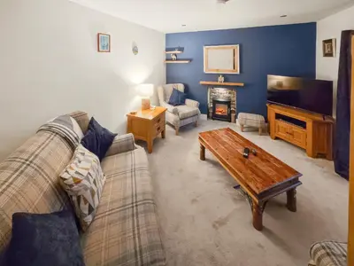 a living room with a couch and a coffee table at Monawilline Cottage in Lamlash