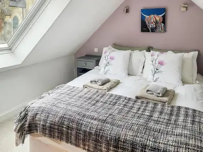 a bedroom with a bed with two pillows on it at Monawilline Cottage in Lamlash