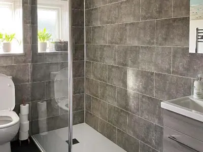 a bathroom with a shower and a toilet and a sink at Monawilline Cottage in Lamlash