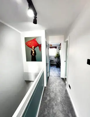 a hallway with a painting of a woman with a red umbrella at Urban 4BR house - Central-FREE parking-NO PARTY in Glasgow
