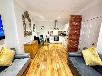 a living room with a couch and a kitchen at Historic Mews House 2BR in Edinburgh City Centre in Edinburgh