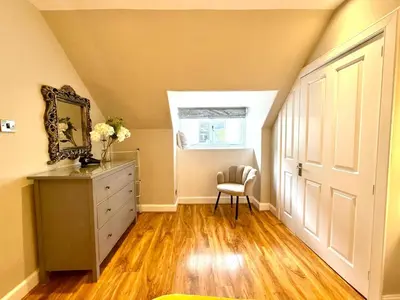 a room with a dresser and a chair and a window at Historic Mews House 2BR in Edinburgh City Centre in Edinburgh