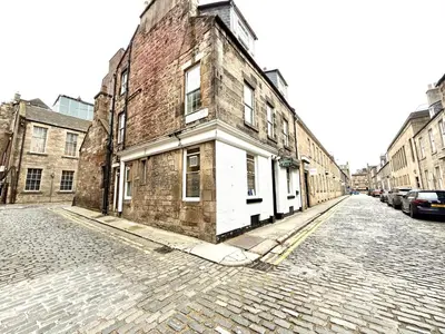 an old brick building on the side of a street at Historic Mews House 2BR in Edinburgh City Centre in Edinburgh