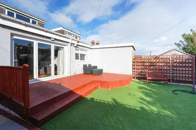 a backyard with a deck with green grass at Seabreeze in Prestwick in Prestwick
