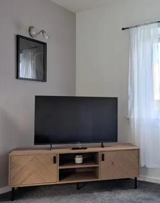 a flat screen tv sitting on top of a wooden entertainment center at Kintyre House in Campbeltown
