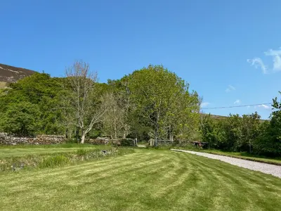 a grass field next to a dirt road at Townhead Mill in Dumfries