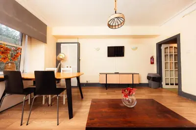 a living room with a table and chairs at Cosy Central Apartment by the Meadows 4 in Edinburgh