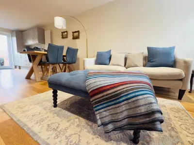 a living room with a couch and a table at Stylish Two-Bedroom Flat with Garden Near Henley Town Centre in Moffat