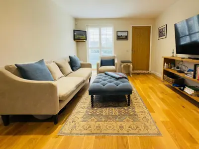 a living room with a couch and a tv at Stylish Two-Bedroom Flat with Garden Near Henley Town Centre in Moffat