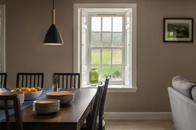 a dining room table with a bowl of fruit and a window at Quarter House in Peebles