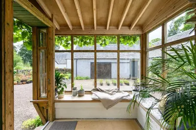 a conservatory with a window with plants in it at Quarter House in Peebles