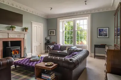 a living room with a couch and a fireplace at Quarter House in Peebles