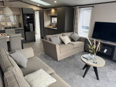 a living room with a couch and a tv at Lime Tree Lodge in Crieff
