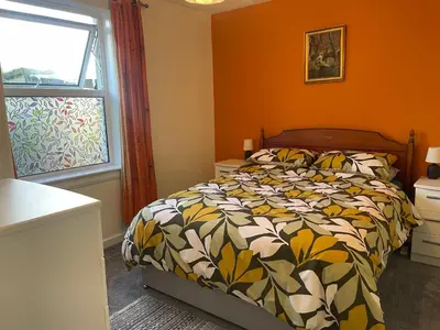a bedroom with a bed and a window at The Wee Flat in Uphall