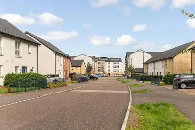 an empty street in a residential neighborhood with houses at Oatlands Oasis-FREE PARKING-2 Minutes from M74 in Glasgow