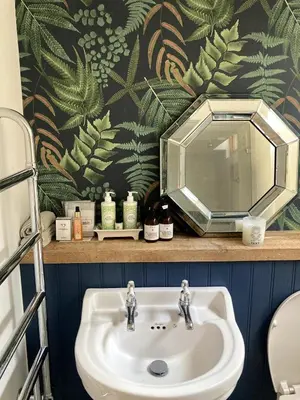 a bathroom sink with a large mirror above it at The Cart Barn in Moffat