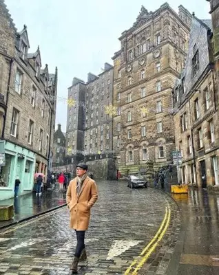 a man walking down a street in the rain at Hutchison apartments in Edinburgh