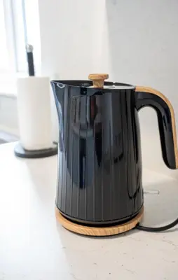 a black tea kettle sitting on top of a counter at California House in Falkirk