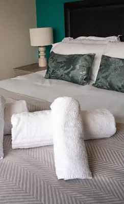 a bed with towels and pillows on it at California House in Falkirk