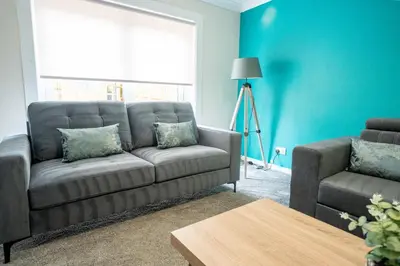 a living room with a couch and a table at Whitburn house in Whitburn