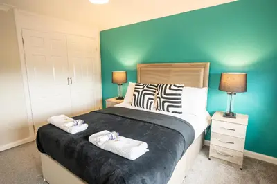a bedroom with a bed with two towels on it at Whitburn house in Whitburn