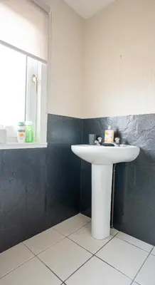 a bathroom with a white sink and a window at Whitburn house in Whitburn