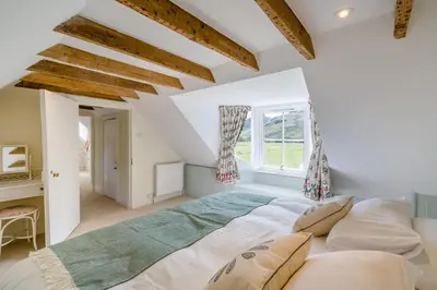 a bedroom with a large bed and a window at 3 Bed in Comrie oc-e33307 in Comrie