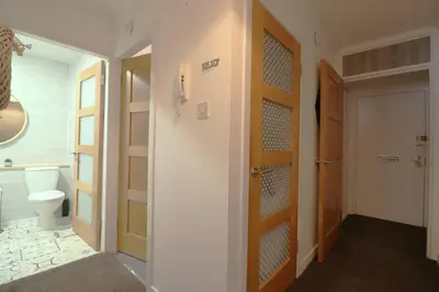 a bathroom with a toilet and a door to a hallway at Cosy 1 bed flat in central Ayr in Ayr