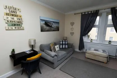 a living room with a couch and a chair at Troon - Coastal Getaway in Troon