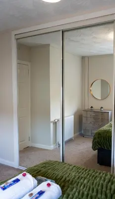 a bedroom with a large mirror and a bed at 2 BDR House At Caledonia Luxe Stays Short Lets & Serviced Accommodation Hamilton in Hamilton