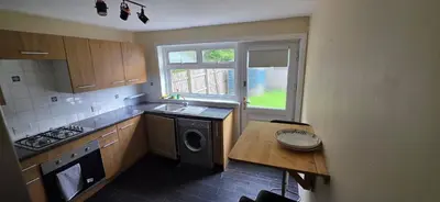 a kitchen with a washer and a table and a window at 3 bedrooms home away from home in Uphall