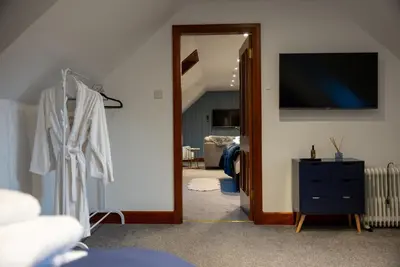a room with a hallway with a mirror and a tv at The Cottage at Barraston Farm in Glasgow