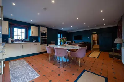 a kitchen with a table and chairs in a room at The Cottage at Barraston Farm in Glasgow