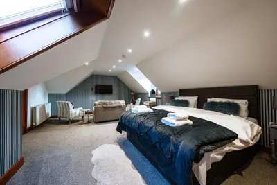 a bedroom with a large bed in a attic at Barraston Farm in Glasgow