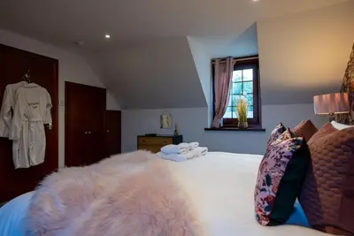 a bedroom with a large bed with a white blanket at Barraston Farm in Glasgow