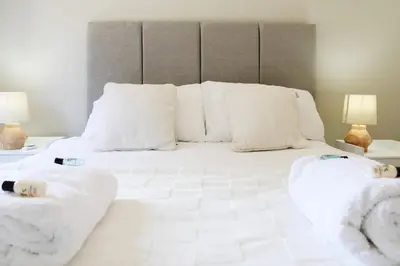 a bed with white sheets and pillows on it at The Sunrise Den, Modern 2-Bed Apartment, Free Parking in Yarrow