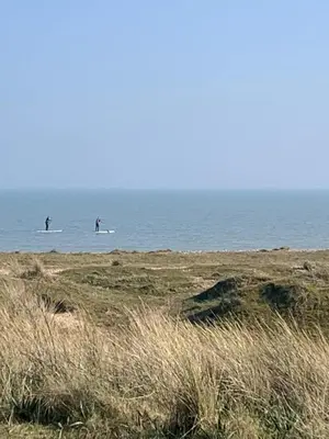 two people on surfboards in the water at the beach at The Beach House in Moffat