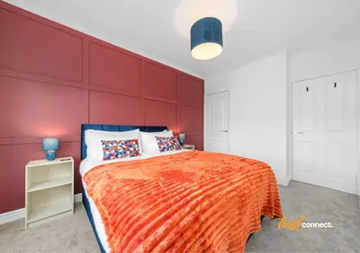 a bedroom with a large red wall at 2 Bed Sleeps 4 with Private Parking in Airdrie in Airdrie