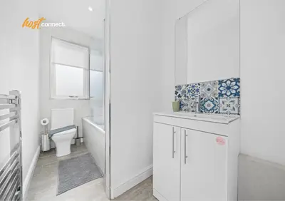 a white bathroom with a toilet and a sink at 2 Bed Sleeps 4 with Private Parking in Airdrie in Airdrie