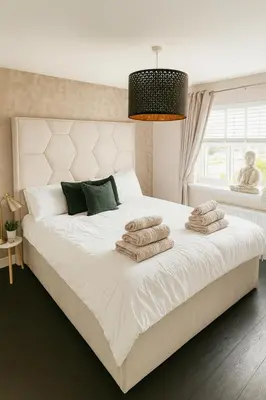 a bedroom with a large white bed with towels on it at 3BR Detached Home, Driveway & Large Rear Garden in Hogganfield