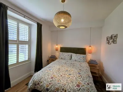 a bedroom with a bed and a large window at High Street Stay - Oban in Oban