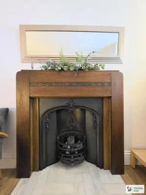 a fireplace in a living room with a mirror at High Street Stay - Oban in Oban