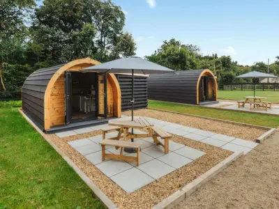 a wooden cabin with an umbrella and a picnic table at Islay - Uk48416 in Dalry
