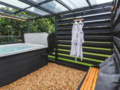 a bath tub sitting next to a wooden bench next to a pool at Islay - Uk48416 in Dalry