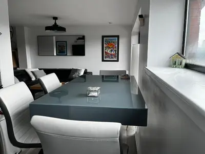 a living room with a blue table and white chairs at City Centre Apartment in Glasgow