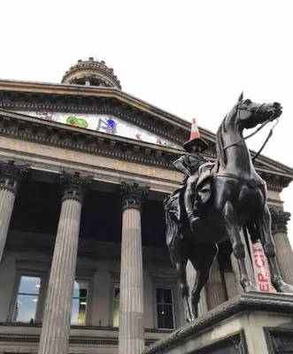 a statue of a horse in front of a building at City Centre Apartment in Glasgow