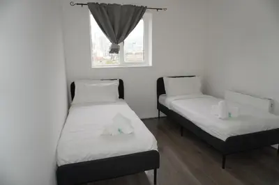 two twin beds in a room with a window at Glasgow Riverview Apartment in Glasgow