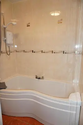 a white bath tub in a bathroom with a shower at Glasgow Riverview Apartment in Glasgow
