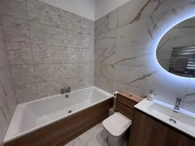 a bathroom with a tub and a toilet and a sink at Taobh na Mara - Macaulay Letting in Helensburgh