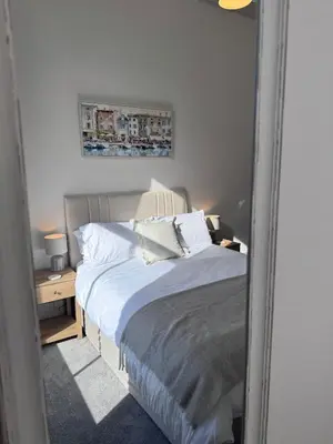 a bedroom with a bed and a mirror at The Comet - Macaulay Letting in Helensburgh